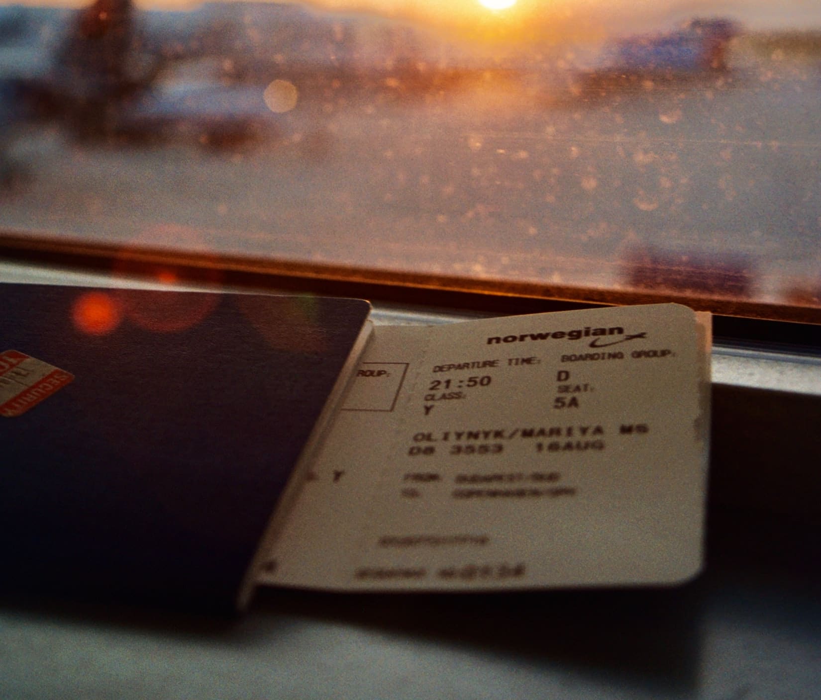 Pass og flybillett i vinduskarm på flyplass